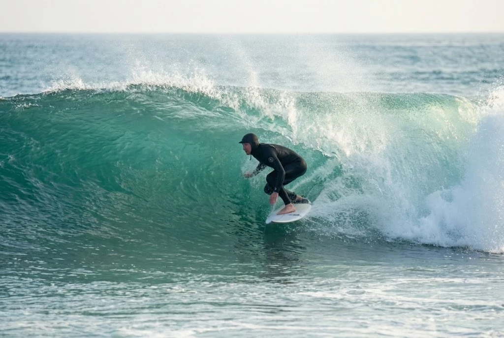 Surfer racing across an emerald wave