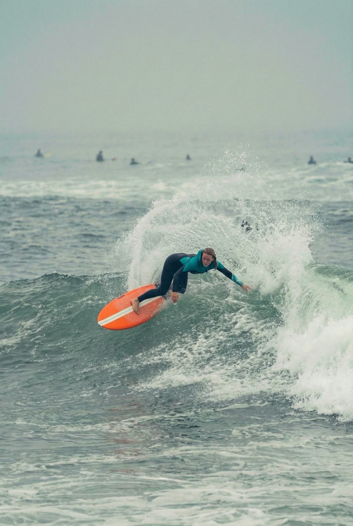 Surfer punching off the lip with a red-railed board